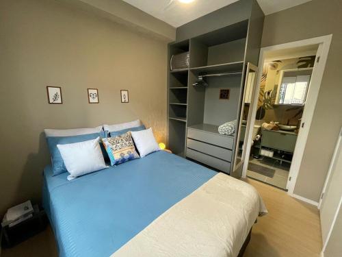 a bedroom with a blue and white bed and a mirror at 8 Studio Liberdade Sé 500'Metrô - 25 de Março - Brás in Sao Paulo