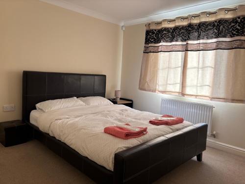 a bedroom with a large bed with red towels on it at Bright 2-Bedroom Family Flat, Wimbledon in London