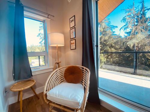a wicker chair in a room with a large window at Haven On The Hill in Port Renfrew