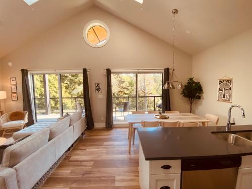 a kitchen and living room with a couch and a table at Haven On The Hill in Port Renfrew