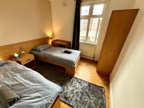 a small bedroom with two beds and a window at Stay 45A in London