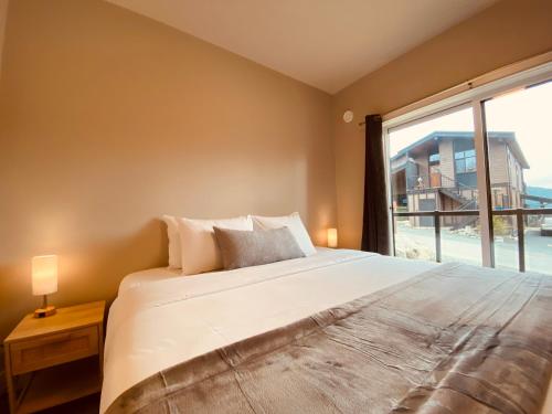 a bedroom with a large bed and a large window at Haven On The Hill in Port Renfrew