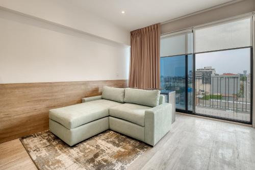 a living room with a couch and a large window at Myla Chapultepec in Mexico City
