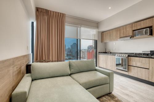 a living room with a couch and a kitchen at Myla Chapultepec in Mexico City