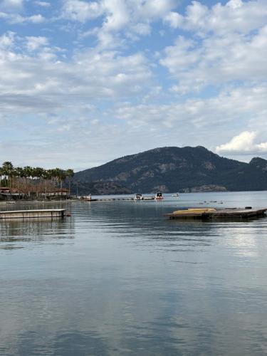 a large body of water with a dock and a mountain at Ebru'ca Pansiyon in Selimiye