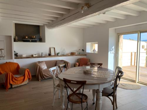 une salle à manger avec une table et des chaises et un salon dans l'établissement Gîte Belle Vue à Savigny proche de Lyon, à Savigny