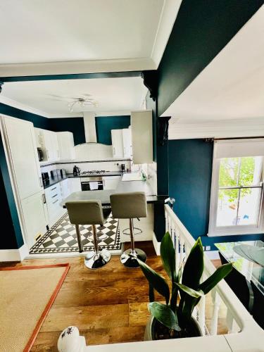 a kitchen with blue walls and two chairs and a table at Richmond charm cozy apartment in Richmond upon Thames