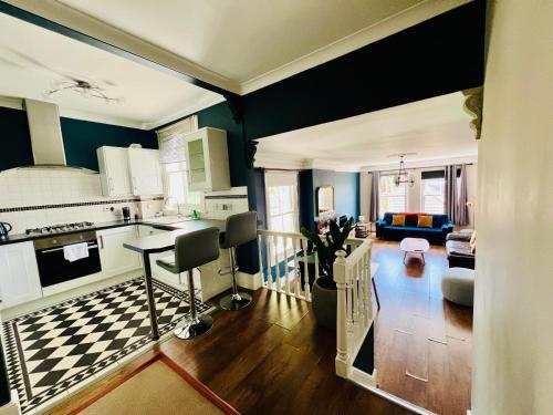 a kitchen and living room with blue walls at Richmond charm cozy apartment in Richmond upon Thames