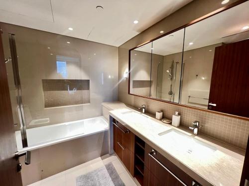 a bathroom with a tub and a sink and a mirror at Elegant apartment Dubai downtown in Dubai