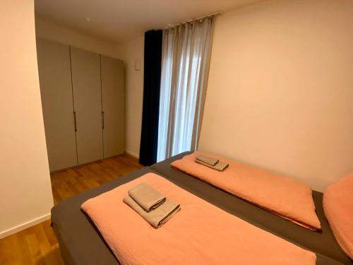a bedroom with two beds with orange sheets and a window at Apartments am Lutherplatz in Potsdam