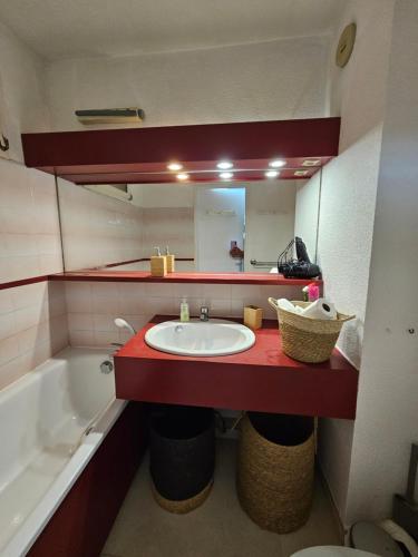 a bathroom with a sink and a mirror and a tub at Le Studio Sur La Côte in Cavalaire-sur-Mer