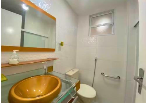 a bathroom with a wooden sink and a toilet at Pé na areia, Prainha in Arraial do Cabo