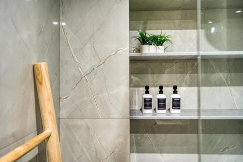 three bottles of wine sitting on a shelf in a bathroom at Windmill Escape Apartments B in Chios