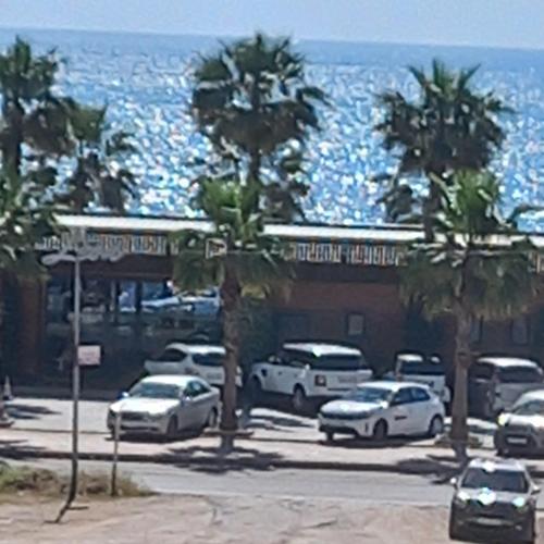 a parking lot with cars parked next to the ocean at Apartament shëngjin lisuss apartments in Shëngjin