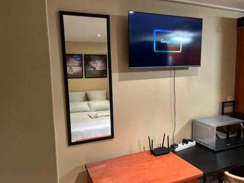 a room with a television on the wall with a bed at Studio Apartment Paarl Central in Paarl