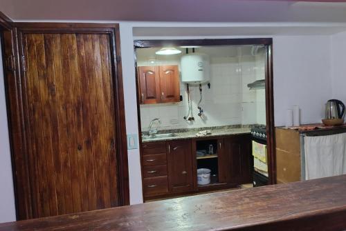 eine Küche mit Holzschränken und einem großen Spiegel in der Unterkunft Departamento en planta alta in Salta