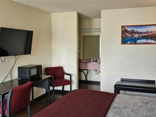 a hotel room with a bed a desk and a television at Sumner Motor Inn in Sumner