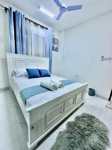 モンバサにあるHarmony 1 Bedroom Apartmentの窓のある部屋にある白いベッド