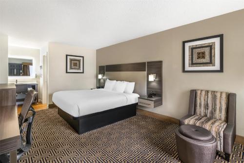 a hotel room with a bed and a chair at Best Western Central Inn in Savannah
