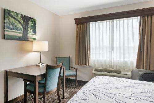 a hotel room with a bed and a desk and chair at Best Western Brookfield in Brookfield