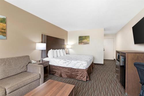 a small hotel room with a bed and a couch at Best Western Brookfield in Brookfield