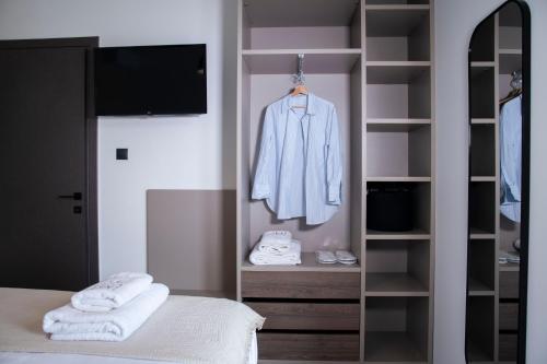 アギア・パラスカヴィにあるThe Mood Residenceのクローゼット、バスローブ、ベッドのある寝室