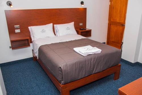 a bed in a hotel room with two towels on it at Hotel Turístico Everest in Huaraz