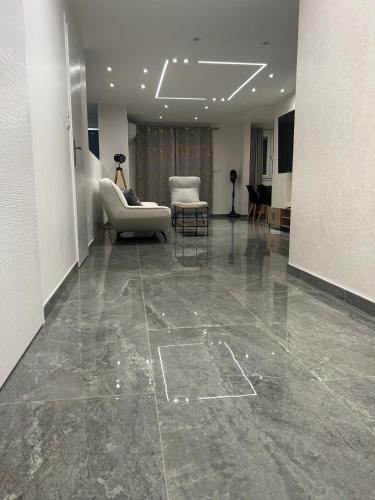 a lobby with a couch and a chair and a table at Appartement Luxe & design Vue mer sur la Promenade des Anglais in Nice