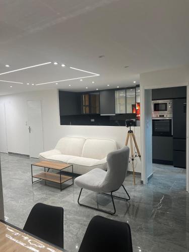 a living room with a white couch and a table at Appartement Luxe & design Vue mer sur la Promenade des Anglais in Nice
