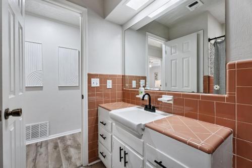 a bathroom with a sink and a mirror at Affordable 5br Near Route 66 Large Groups #12 in Oklahoma City