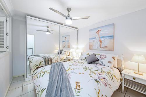 a bedroom with two beds and a mirror at Tiny Comfy flat with Bikes in Coolum Beach