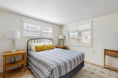 Un dormitorio con una cama y dos ventanas. en Lobster Trap, en Boothbay Harbor