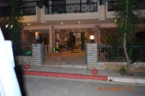 a house with a porch and a building at Apartments Zoumperi in Nea Makri