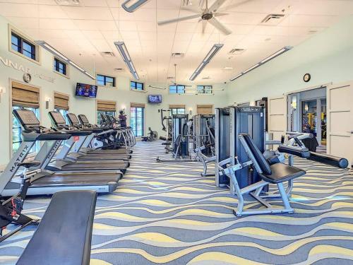a gym with rows of treadmills and machines at Disney-Themed Townhome in ChampionsGate Resort 15 min from Disney World with 7 Pools, Gym, Golf, Lazy River, Water Park, Arcades, Theatre, and More! in Kissimmee