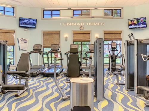 a fitness room with treadmills and exercise equipment at Disney-Themed Townhome in ChampionsGate Resort 15 min from Disney World with 7 Pools, Gym, Golf, Lazy River, Water Park, Arcades, Theatre, and More! in Kissimmee