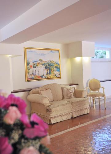 a living room with a couch and a painting on the wall at Hotel Villa Fraulo in Ravello