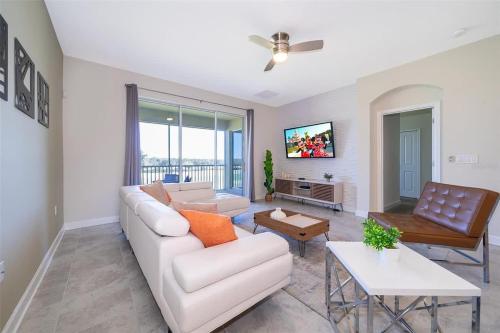 a living room with a couch and a table at Wonderful Disney-Themed Home in ChampionsGate Resort 15 min from Disney World with 7 pools, Club houses, Water Park, Gym, Arcades, Lazy River, Golf, and More! in Kissimmee