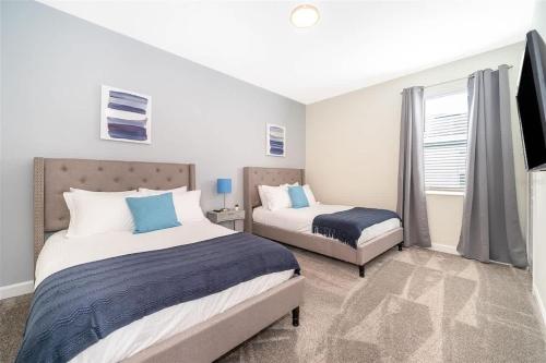 a bedroom with two beds and a window at Wonderful Disney-Themed Home in ChampionsGate Resort 15 min from Disney World with 7 pools, Club houses, Water Park, Gym, Arcades, Lazy River, Golf, and More! in Kissimmee