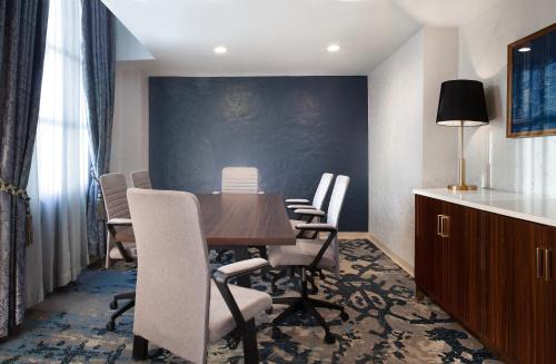 a conference room with a wooden table and chairs at Hotel Royer Urbana Champaign, Tapestry Collection by Hilton in Champaign