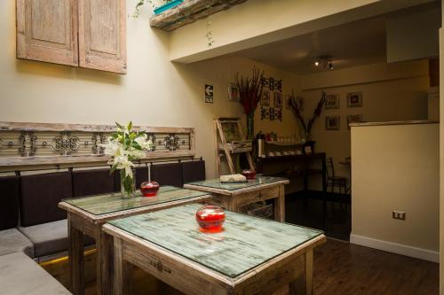 a kitchen with two wooden tables and a refrigerator at Wakapunku Boutique Hotel in Cusco