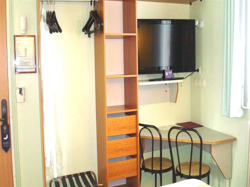a small room with a desk and two chairs in a room at Hotel De Rosny in Tours