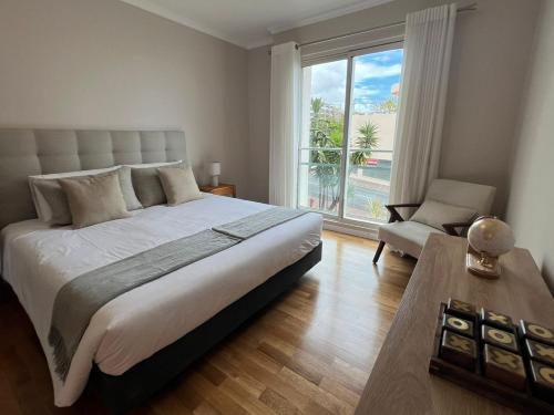 a bedroom with a large bed and a large window at Modern Urban Apartment in Funchal