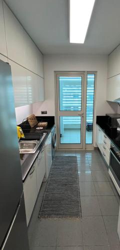 a kitchen with white cabinets and a large window at Modern Urban Apartment in Funchal
