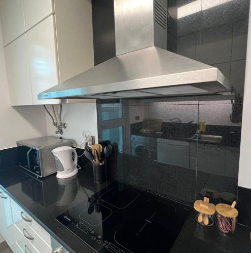 a kitchen with a sink and a stove top oven at Modern Urban Apartment in Funchal