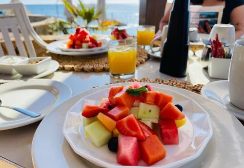 um prato de fruta numa mesa com um prato de sumo em Punta Pescadero Paradise Hotel & Villas em Los Barriles