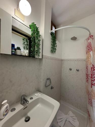 a white bathroom with a sink and a shower at Praiano Amalfi Coast Casa con Vista Mare in Praiano