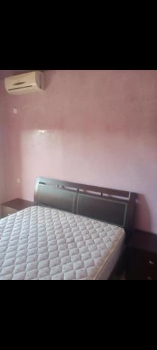 an empty bed in a room with at Appart 2 CH lumineux et une piscine pour votre séjour in Marrakech