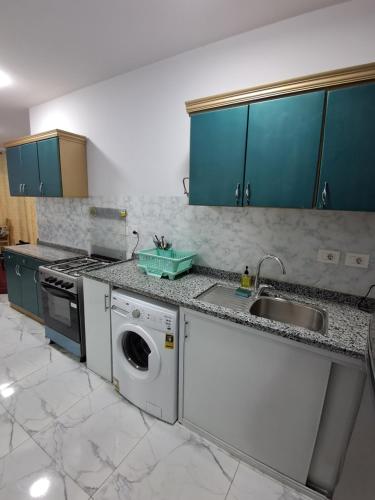 a kitchen with a sink and a washing machine at بورتو سعيد شاليه غرفة وصالة ببورسعيد in Port Said