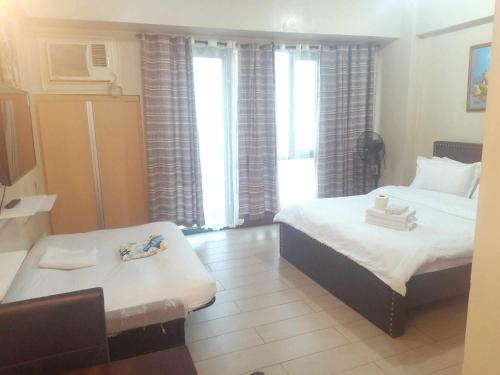 Una habitación con dos camas y una mesa dentro. en Affordable Hotels Condotel Here Naia 1 ,2,3 And 4, en Manila