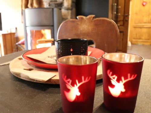two red cups with reindeers on them sitting on a table at La Linotte in Arville